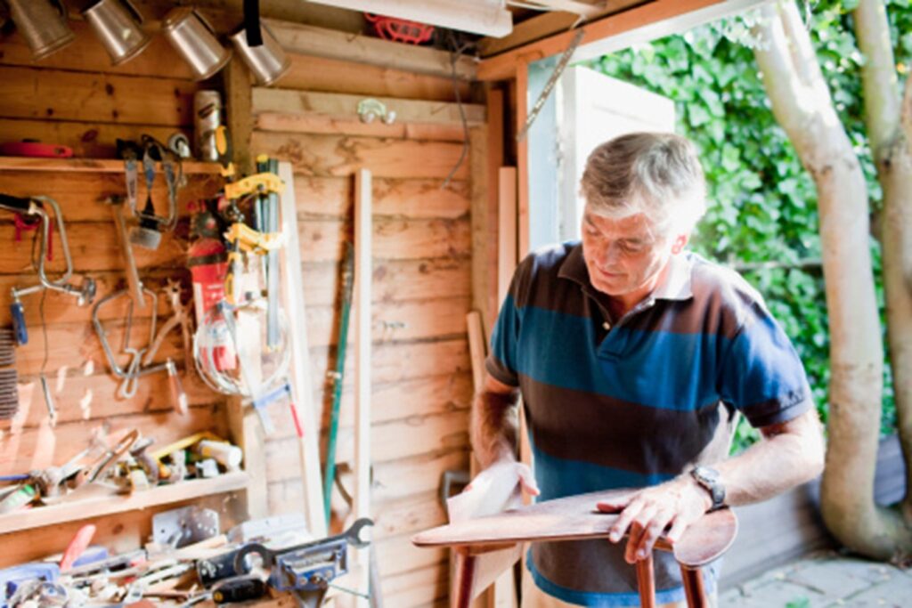 Older man woodworking in shed